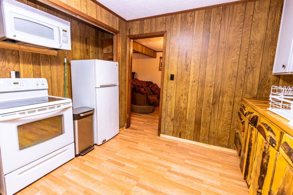 The Arlin Hays Tiny Home in San Augustine - Full Kitchen with an eclectic stove, microwave, and refrigerator.